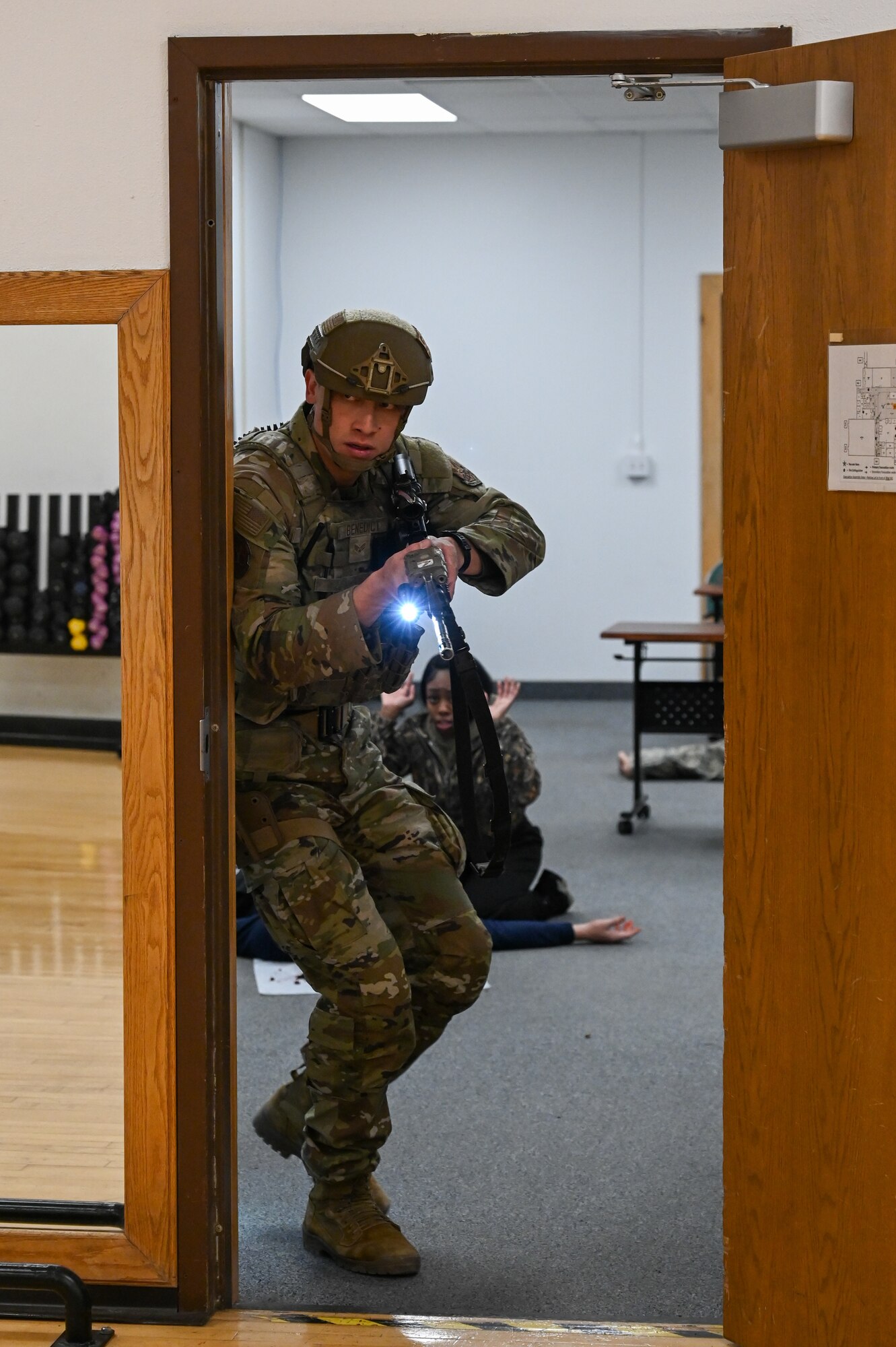 Uniformed personnel provide aid and security to simulated victims of a simulated active shooter.