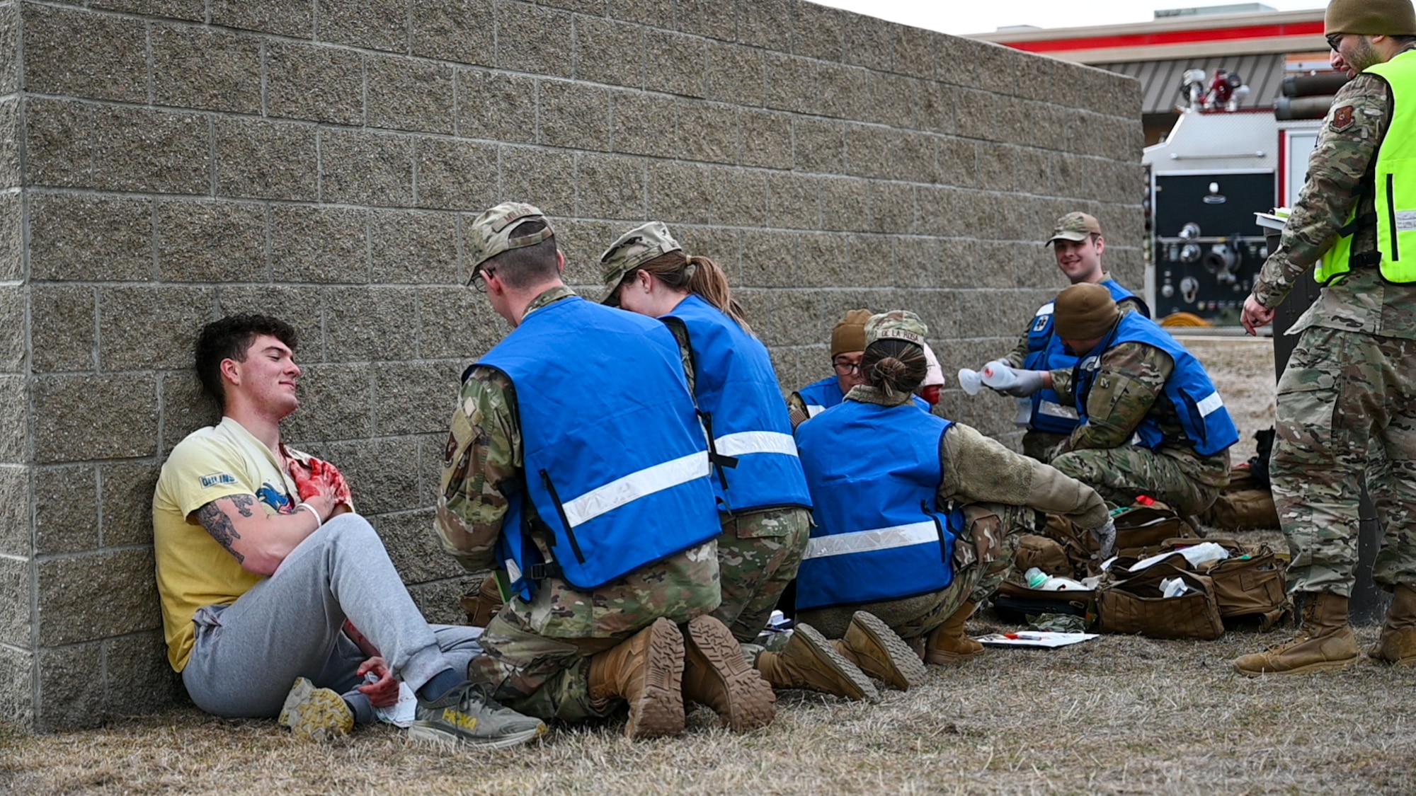 Uniformed personnel provide aid and security to simulated victims of a simulated active shooter.