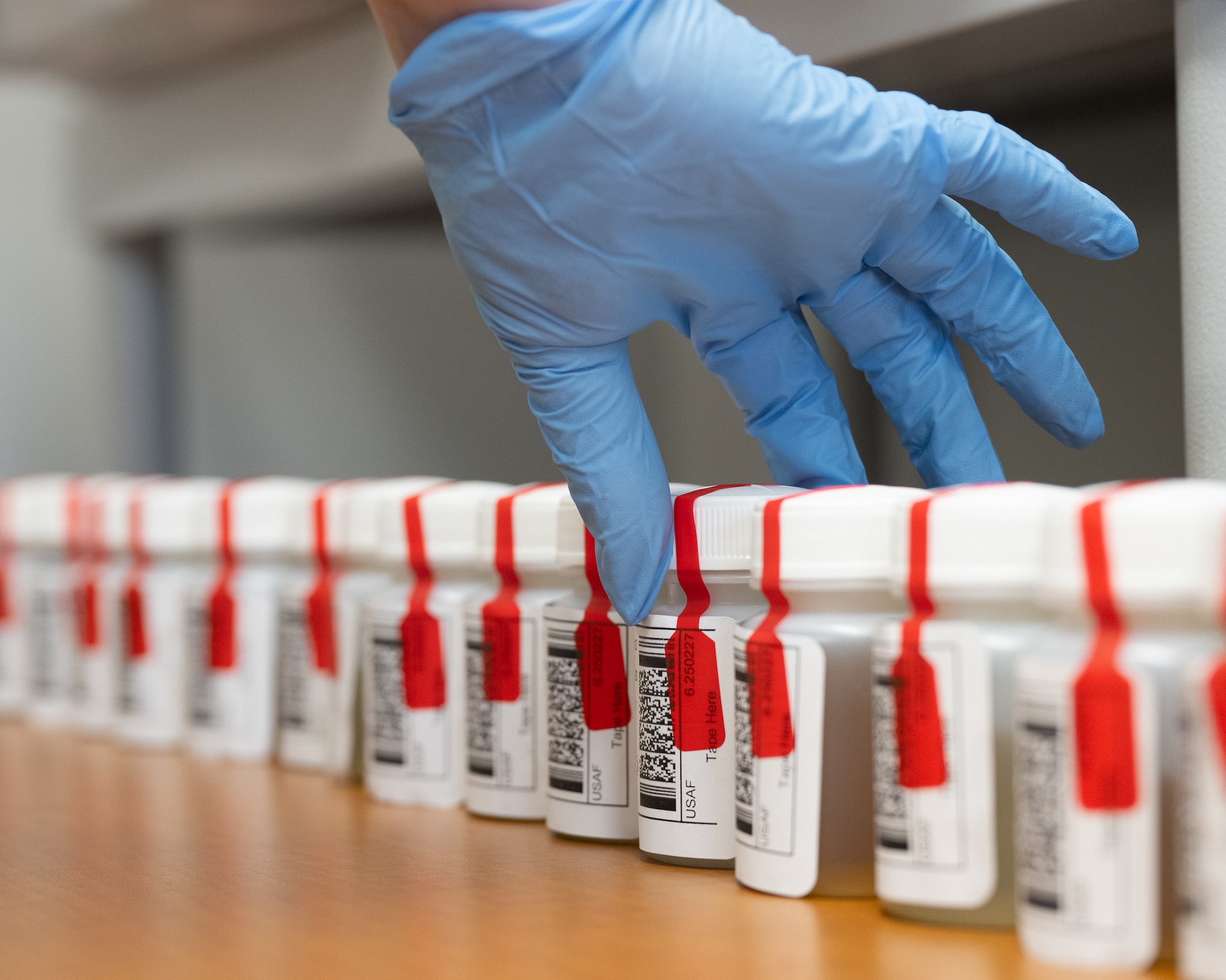 Abbey Hill, 436th Airlift Wing Drug Demand Reduction Program manager, conducts a quality assurance inspection on urine samples during a random drug screening at Dover Air Force Base, Delaware, Feb. 27, 2025. The DDRP staff administers between 270 to 315 drug tests each month. (U.S. Air Force photo by Mauricio Campino)