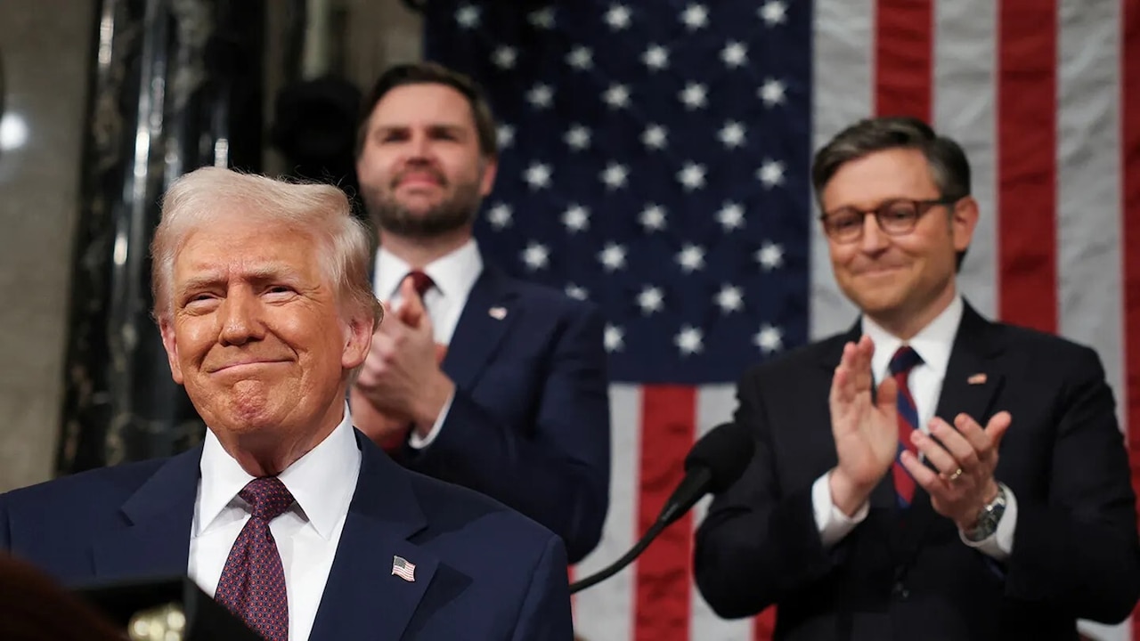 Three men in suits stand at a podium.
