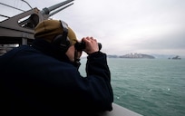 Intelligence Specialist 2nd Class Thomas Gammon, of Georgetown, Texas, stands lookout watch aboard the Nimitz-class aircraft carrier USS Carl Vinson (CVN 70) as the ship pulls into Busan, Republic of Korea for a scheduled port visit, March 2, 2025.