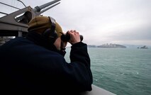 Intelligence Specialist 2nd Class Thomas Gammon, of Georgetown, Texas, stands lookout watch aboard the Nimitz-class aircraft carrier USS Carl Vinson (CVN 70) as the ship pulls into Busan, Republic of Korea for a scheduled port visit, March 2, 2025.