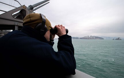Intelligence Specialist 2nd Class Thomas Gammon, of Georgetown, Texas, stands lookout watch aboard the Nimitz-class aircraft carrier USS Carl Vinson (CVN 70) as the ship pulls into Busan, Republic of Korea for a scheduled port visit, March 2, 2025.