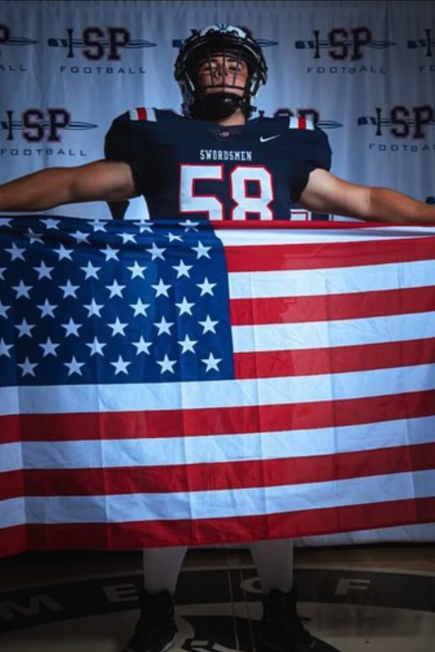 A football player holds an American flag.
