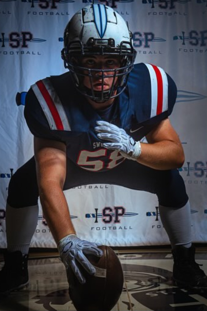 A football play assumes a three-point stance.