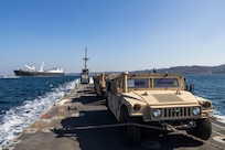 High Mobility Multi-Purpose Wheeled Vehicles with 3rd Marine Logistics Group are transported by an Improved Navy Lighterage System with the United States Naval Ship Dahl (T-AKR 312) in the background during a 3rd MLG instream offload operation as part of Freedom Banner 25 off the coast of Republic of Korea Marine Corps Base Pohang, South Korea, Feb. 28, 2025.