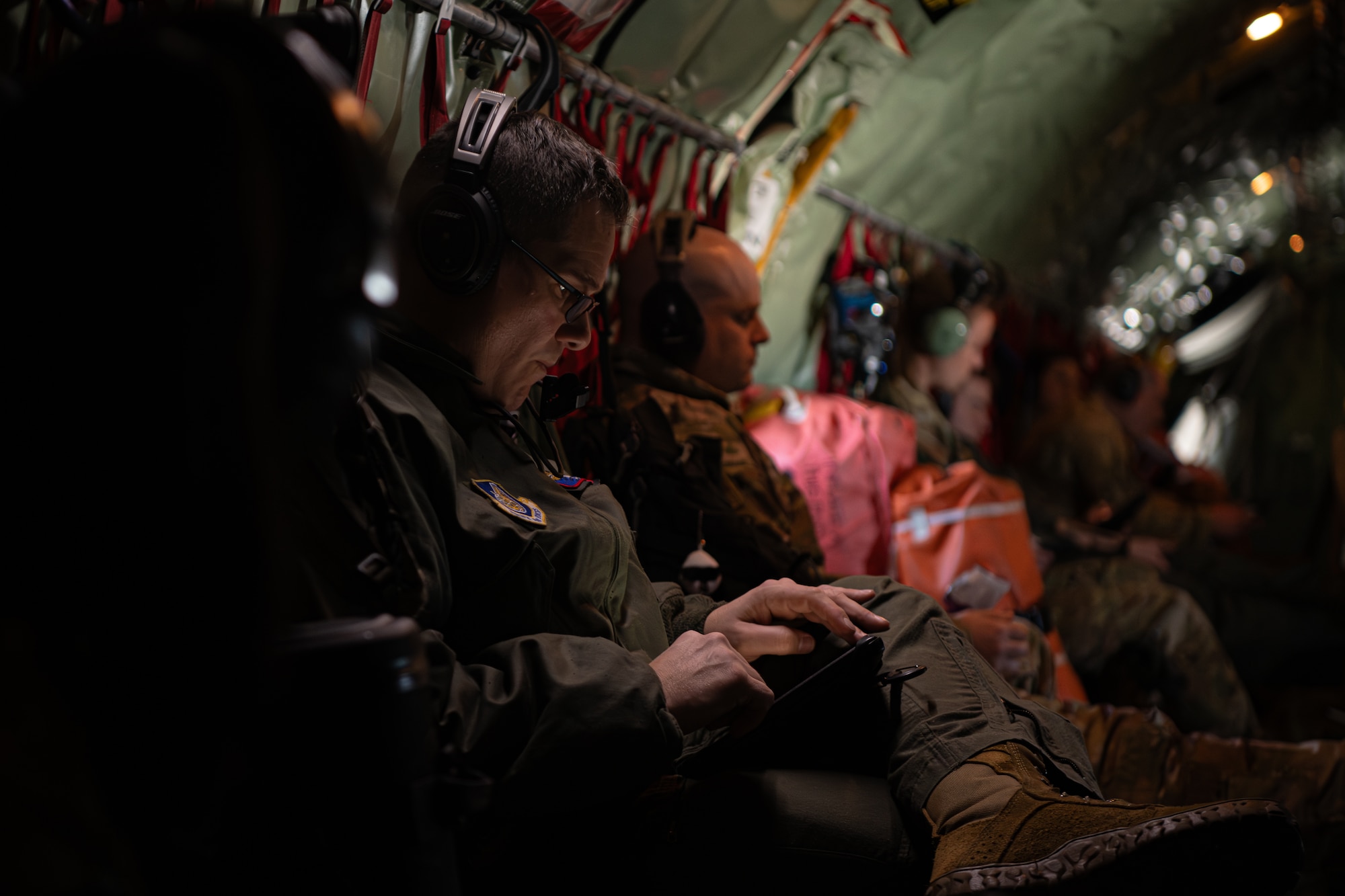 A man looks at a tablet in the fuselage of an aircraft.