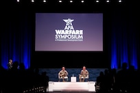 Two military members speak at a panel.