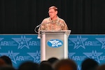 A Space Force general speaks at a lectern.
