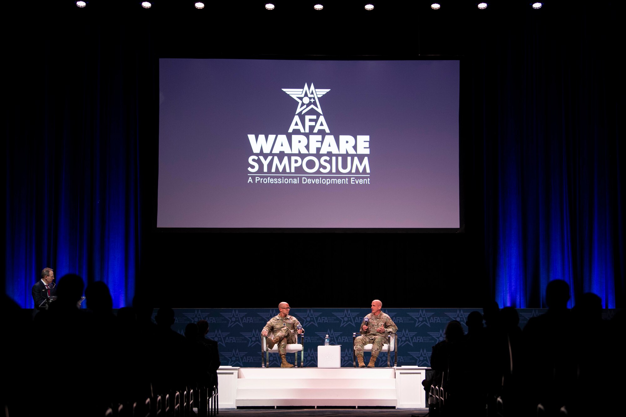 Two military members speak at a panel.
