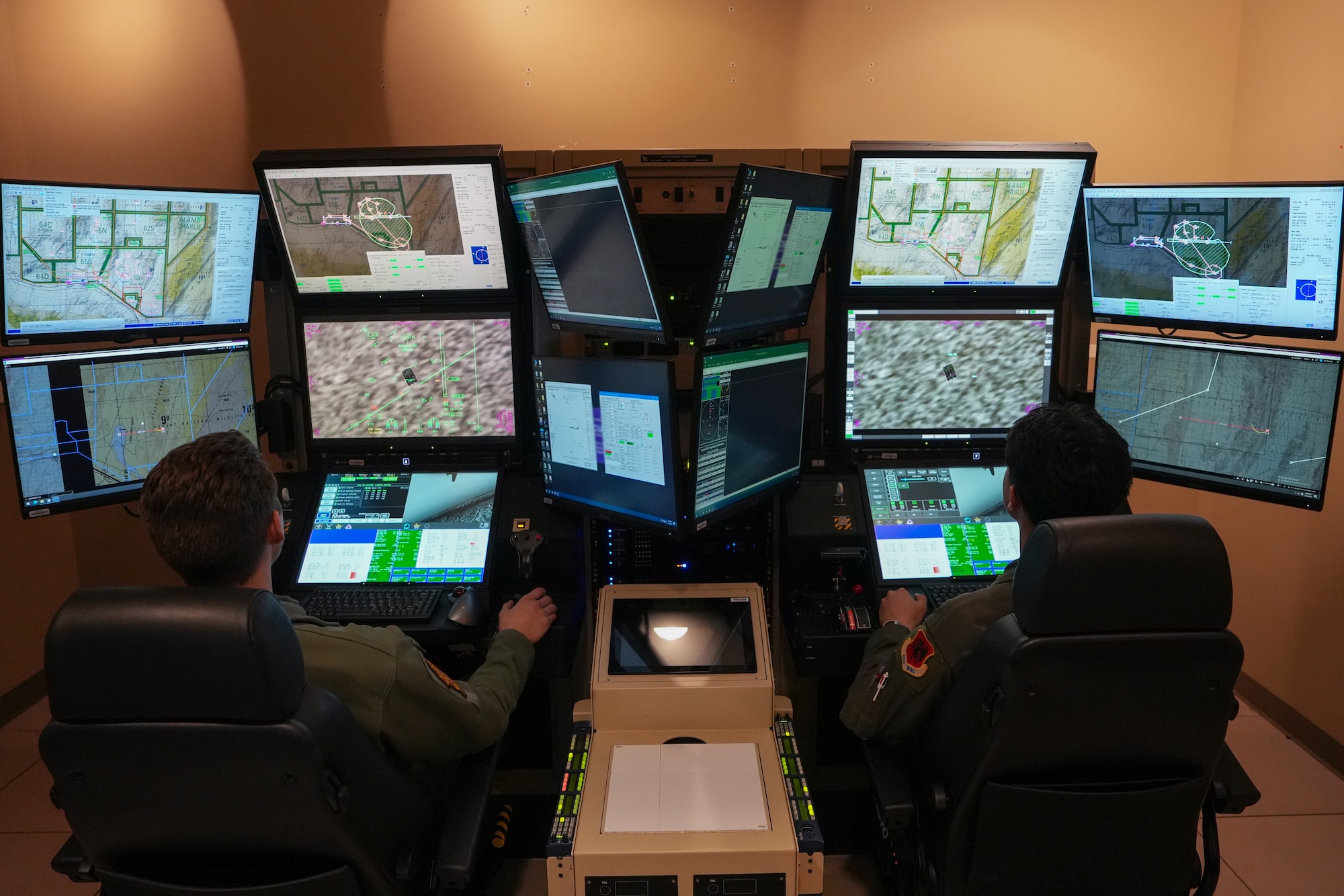 Two men in military uniforms operate a flight simulator.