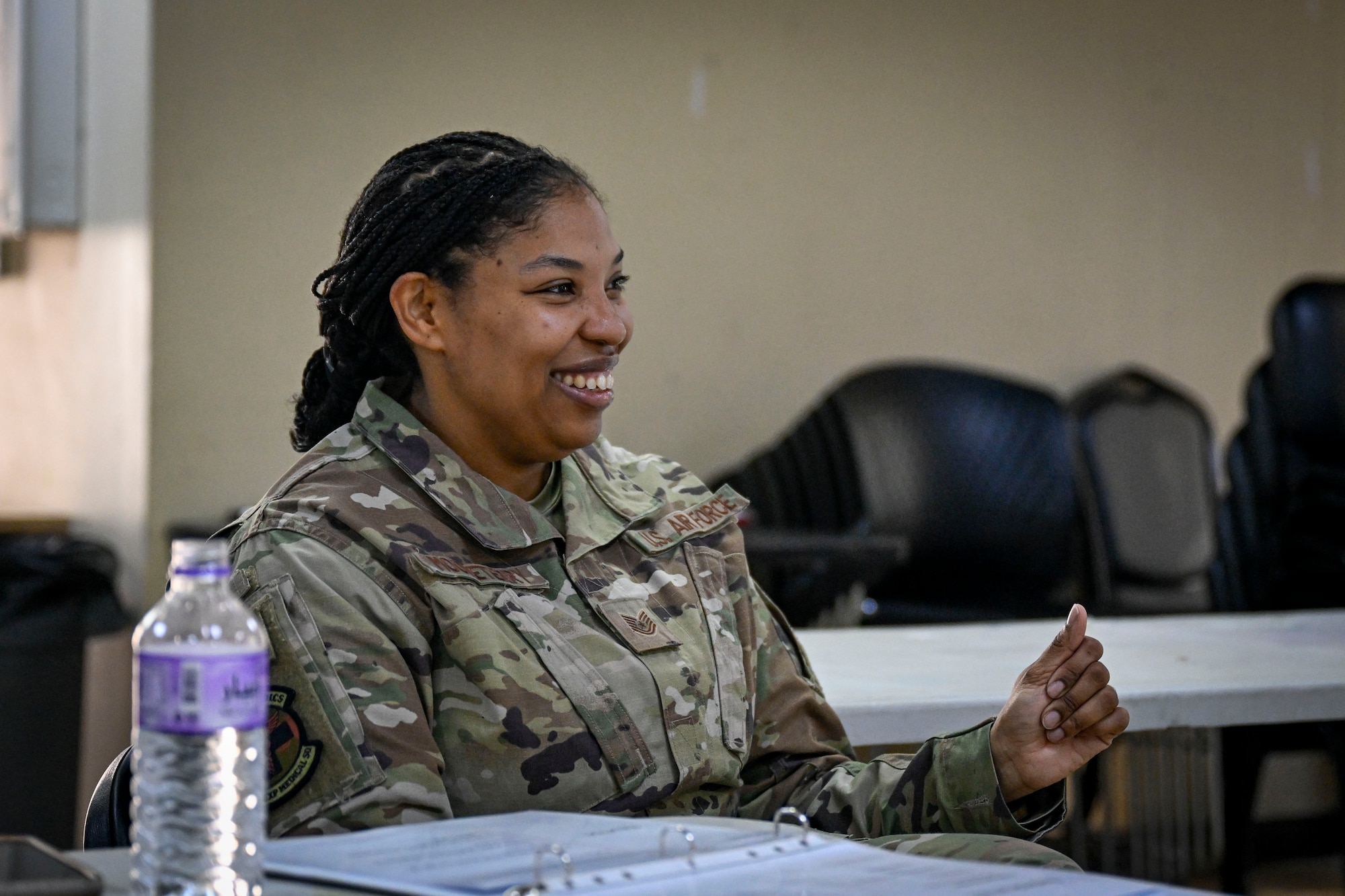 A U.S. Air Force Airman smiles sitting down.