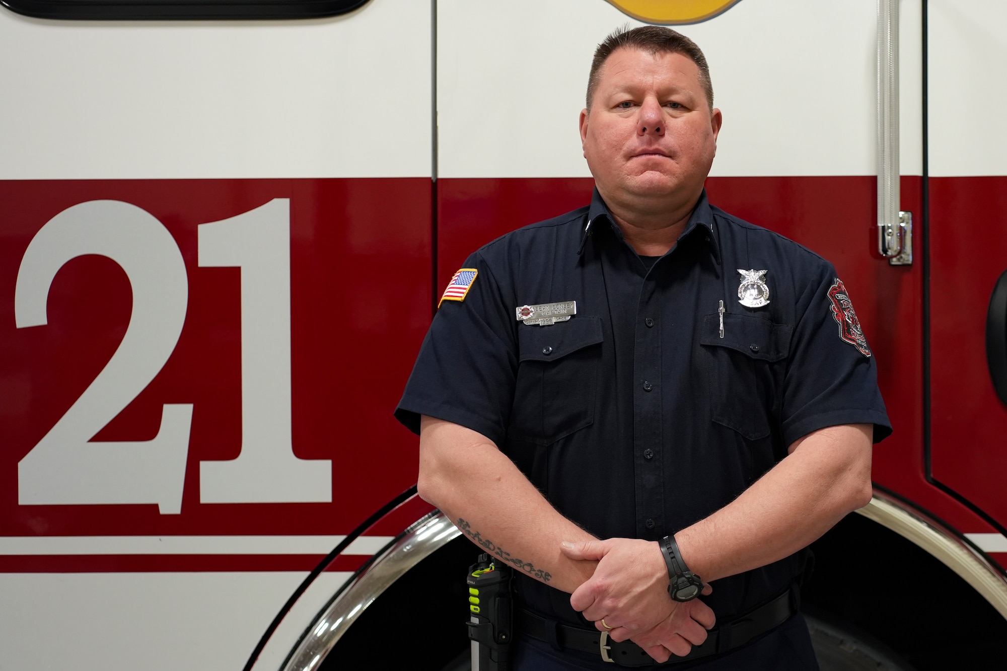 A man stands in front a fire truck.