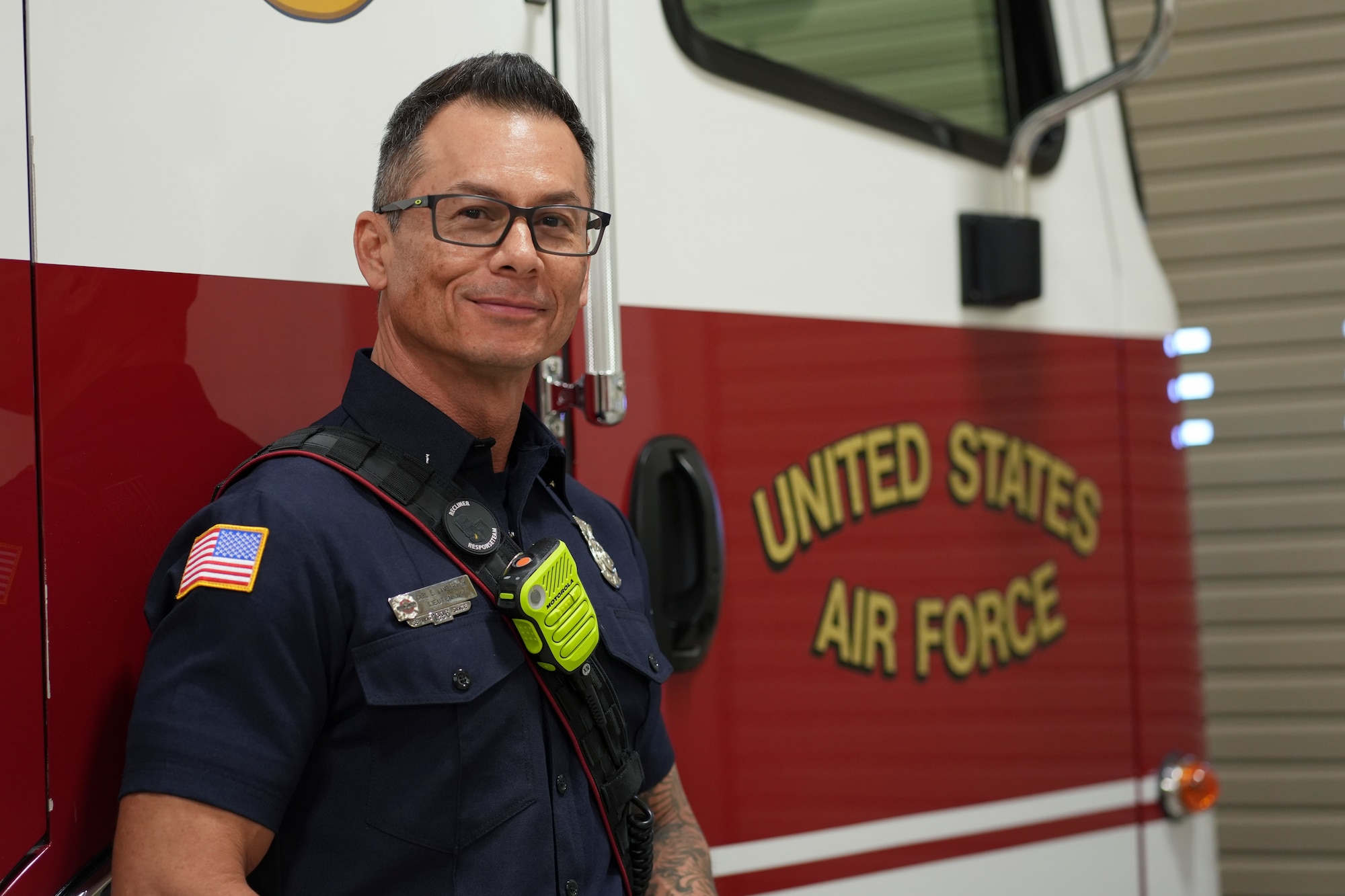 A man stands in front of a fire truck.