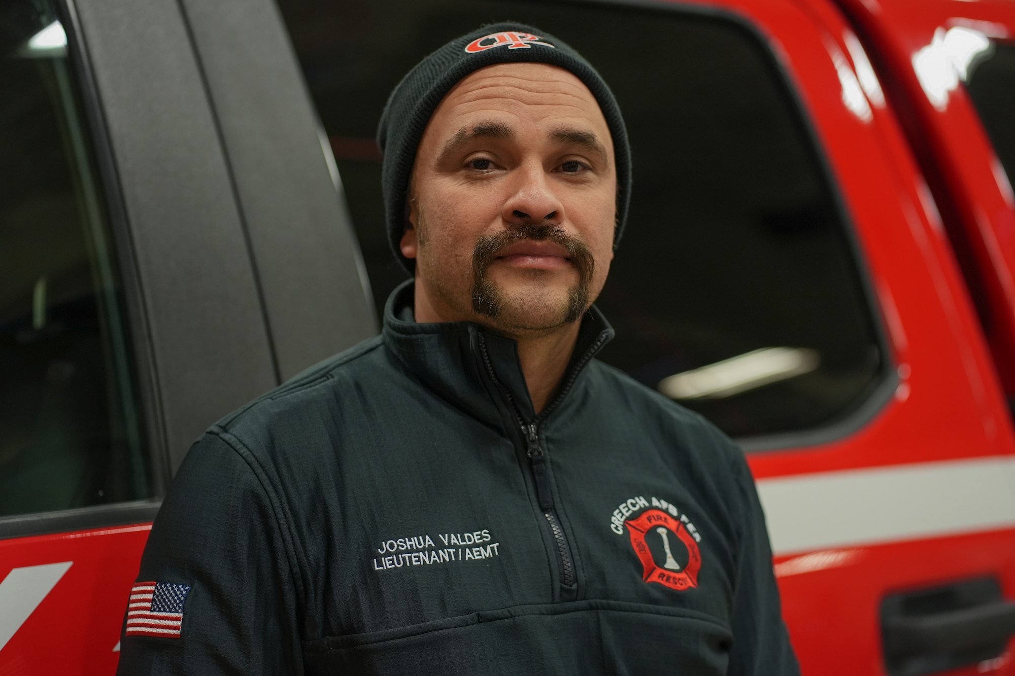 A man stands in front of a fire truck.