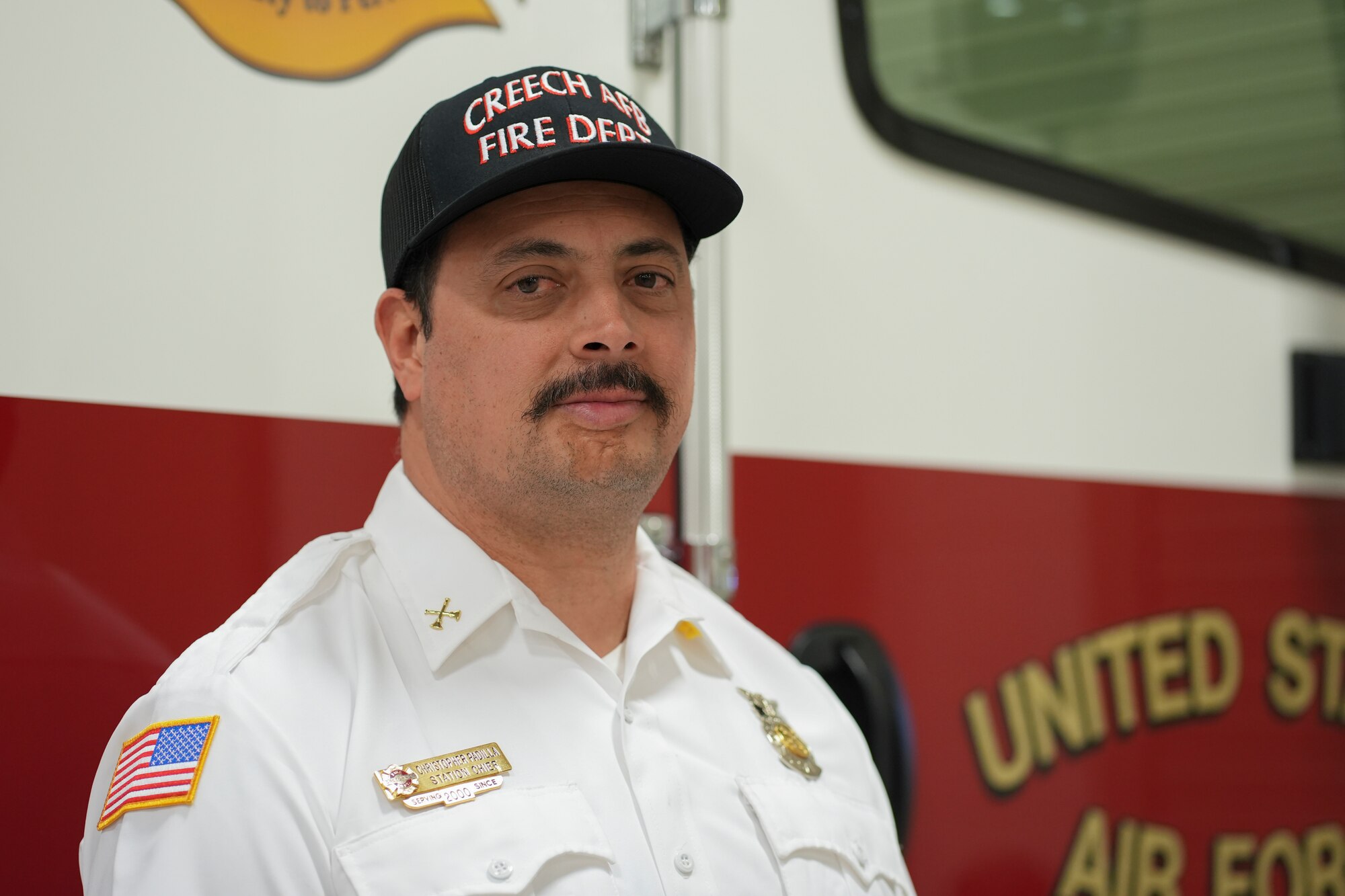 A man stands in front of a fire truck.