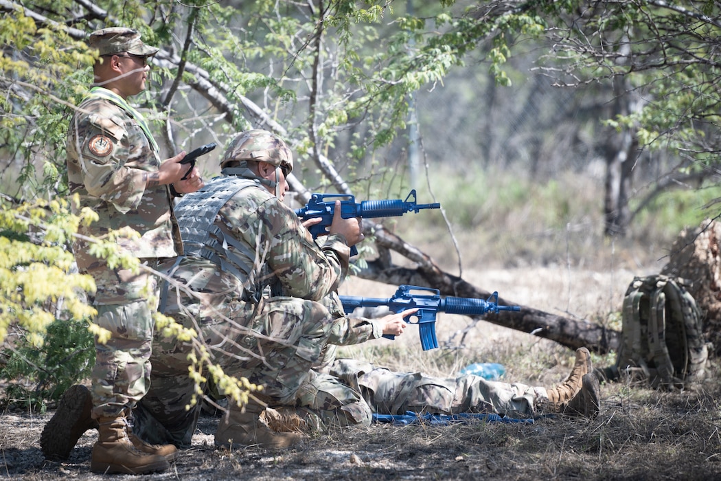 An exercise cadre monitors Airmen protecting an injured member during a field training exercise at Joint Base Pearl Harbor-Hickam, Hawaii, Feb. 2, 2025. The exercise tested the Airmen's tactical abilities and emphasized the importance of mental resilience and decision-making under pressure.