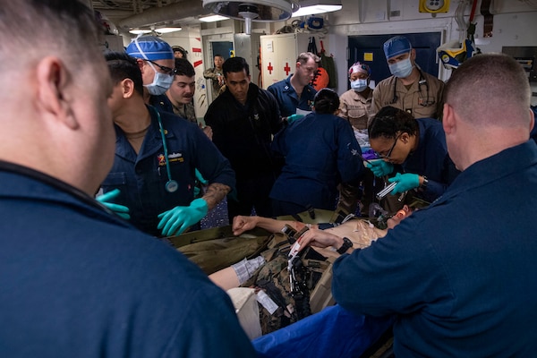 PHILIPPINE SEA (Feb. 5, 2025) Sailors assigned to the forward-deployed amphibious assault ship USS America (LHA 6) and Fleet Surgical Team (FST) 7, assess a simulated casualty in the ship’s medical department during a mass casualty drill in the Philippine Sea, Feb. 5. America, lead ship of the America Amphibious Ready Group, along with the 31st Marine Expeditionary Unit, are underway conducting routine operations in the U.S. 7th Fleet area of operations. U.S. 7th Fleet is the U.S. Navy’s largest forward-deployed numbered fleet, and routinely interacts and operates with allies and partners in preserving a free and open Indo-Pacific region (U.S. Navy photo by Mass Communication Specialist Seaman Jeadan Andre)