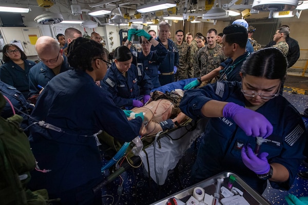 250205-N-QR506-1084 PHILIPPINE SEA (Feb. 5, 2025) Sailors assigned to the forward-deployed amphibious assault ship USS America (LHA 6), Fleet Surgical Team (FST) 7, and the 31st Marine Expeditionary Unit (MEU) assess a simulated casualty in the ship’s medical bay during a mass casualty drill in the Philippine Sea, Feb. 5. America, lead ship of the America Amphibious Ready Group, along with the 31st Marine Expeditionary Unit, are underway conducting routine operations in the U.S. 7th Fleet area of operations. U.S. 7th Fleet is the U.S. Navy’s largest forward-deployed numbered fleet, and routinely interacts and operates with allies and partners in preserving a free and open Indo-Pacific region (U.S. Navy photo by Mass Communication Specialist Seaman Jeadan Andre)
