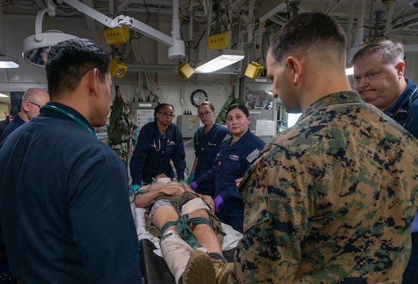 250205-N-QR506-1125 PHILIPPINE SEA (Feb. 5, 2025) Sailors assigned to the forward-deployed amphibious assault ship USS America (LHA 6), Fleet Surgical Team (FST) 7, and the 31st Marine Expeditionary Unit (MEU) assess a simulated casualty in the ship’s medical bay during a mass casualty drill in the Philippine Sea, Feb. 5. America, lead ship of the America Amphibious Ready Group, along with the 31st Marine Expeditionary Unit, are underway conducting routine operations in the U.S. 7th Fleet area of operations. U.S. 7th Fleet is the U.S. Navy’s largest forward-deployed numbered fleet, and routinely interacts and operates with allies and partners in preserving a free and open Indo-Pacific region (U.S. Navy photo by Mass Communication Specialist Seaman Jeadan Andre)