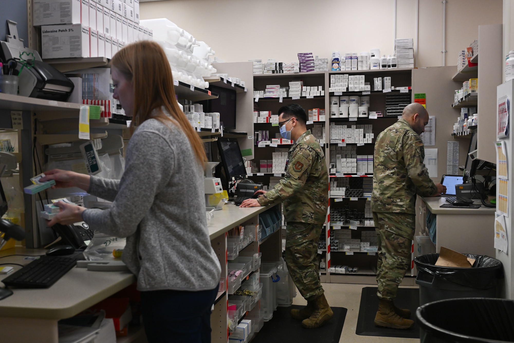 Airmen and pharmacy technician work in pharmacy.