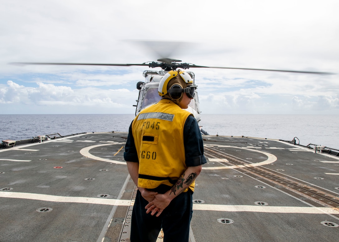Boatswain’s Mate 2nd Class Kade Wakefield, from Corning, New York, prepares to signal to pilots in a NH-90 Neptune helicopter assigned to Royal Netherlands Navy Holland-class offshore patrol vessel HNLMS Groningen (P843), during flight operations aboard Ticonderoga-class guided-missile cruiser USS Normandy (CG 60) while conducting trilateral operations including the U.S., United Kingdom Royal Navy, and Royal Netherlands Navy in the Caribbean Sea, March 3, 2025. USS Normandy is scheduled to protect U.S. interests in the region and strengthen maritime partnerships through trilateral and multinational maritime operations and Theater Security Cooperation (TSC) port visits. U.S. Naval Forces Southern Command/U.S. 4th Fleet is the maritime component of U.S. Southern Command and the trusted maritime partner for Caribbean, Central, and South American maritime forces leading to improved unity, security, and stability. (U.S. Navy photo by Mass Communication Specialist 1st Class Samantha Oblander/Released)