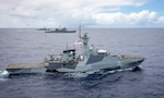United Kingdom Royal Navy River-class offshore patrol vessel HMS Medway (P 223) steams alongside Ticonderoga-class guided-missile cruiser USS Normandy (CG 60) and Arleigh Burke-class guided-missile destroyer USS Thomas Hudner (DDG 116) as a NH-90 Neptune helicopter assigned to Royal Netherlands Navy Holland-class offshore patrol vessel HNLMS Groningen (P843) flies in the distance while conducting trilateral operations in the Caribbean Sea, March 3, 2025. USS Normandy  and USS Thomas Hudner are scheduled to protect U.S. interests in the region and strengthen maritime partnerships through bilateral, trilateral, and multinational maritime operations and Theater Security Cooperation (TSC) port visits. U.S. Naval Forces Southern Command/U.S. 4th Fleet is the maritime component of U.S. Southern Command and the trusted maritime partner for Caribbean, Central, and South American maritime forces leading to improved unity, security, and stability. (U.S. Navy photo by Mass Communication Specialist 2nd Class Dylan M. Kinee/Released)