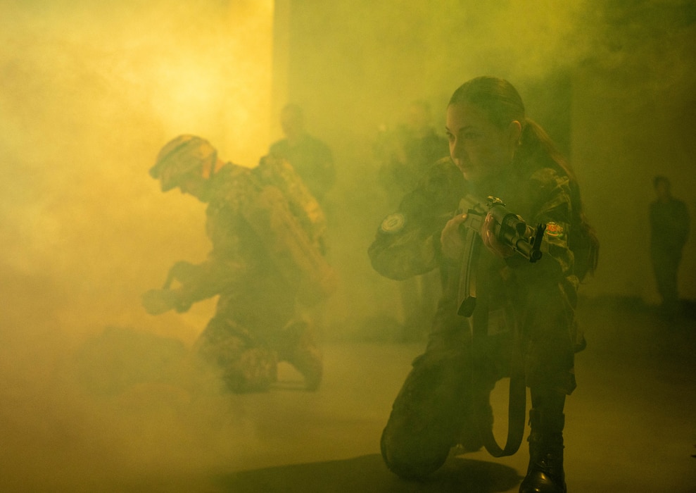 Tereza Ivanova, a Bulgarian nursing student, provides simulated cover fire while medics tend to a casualty at the Military Medical Simulation Center during Bulgarian Multilateral Medical Simulation Training Engagement in Sofia, Bulgaria, Feb. 27, 2025.