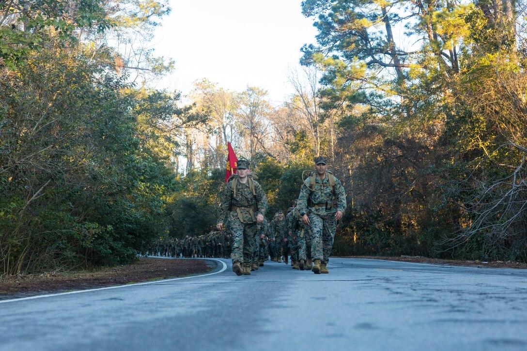 U.S. Marine Corps Lt. Col. Chad Phillips, left, battalion commander, Headquarters and Service Battalion, 2nd Marine Logistics Group, and Sgt. Maj. Devon Fischer, battalion sergeant major, H&S Bn, 2nd MLG, lead a 10km hike on Camp Lejeune, North Carolina, Feb. 28, 2025. The 10km hike was conducted to enhance combat endurance and train for more challenging battalion hikes in the future. (U.S. Marine Corps photo by Sgt. Mary Torres)