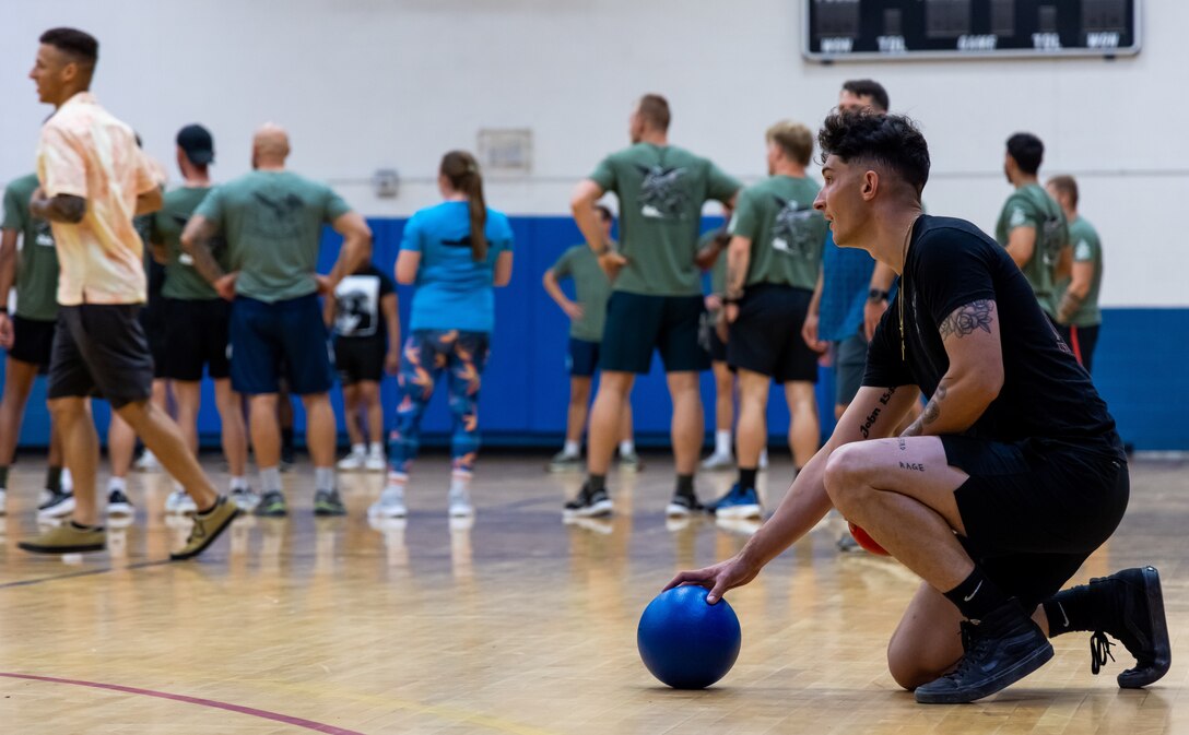 U.S. Marine Corps Sgt. Payton Orlando, a joint terminal attack controller with 2nd Air Naval Gunfire Liaison Company, II Marine Expeditionary Force Information Group, picks up a dodgeball while participating in a dodgeball tournament during Burmese Chase 24 at Marine Corps Base Camp Lejeune, North Carolina, Sept. 27, 2024. Burmese Chase is an annual U.S. led, multilateral exercise that includes training on integration of ground and air fires, infantry tactics and naval gunfire alongside NATO allies. (U.S. Marine Corps photo by Lance Cpl. Shannen Perkins)