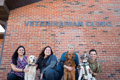 The staff at the Scott Veterinary Treatment Facility pose with dogs outside the facility.
