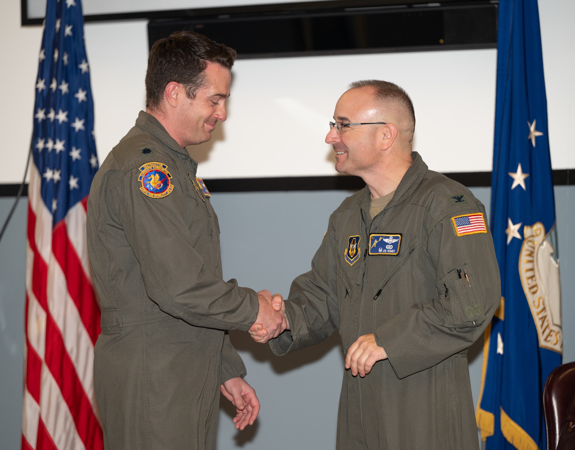 Col Romeo shakes hands with new AMOS squadron commander Lt Col Aaron Jones.