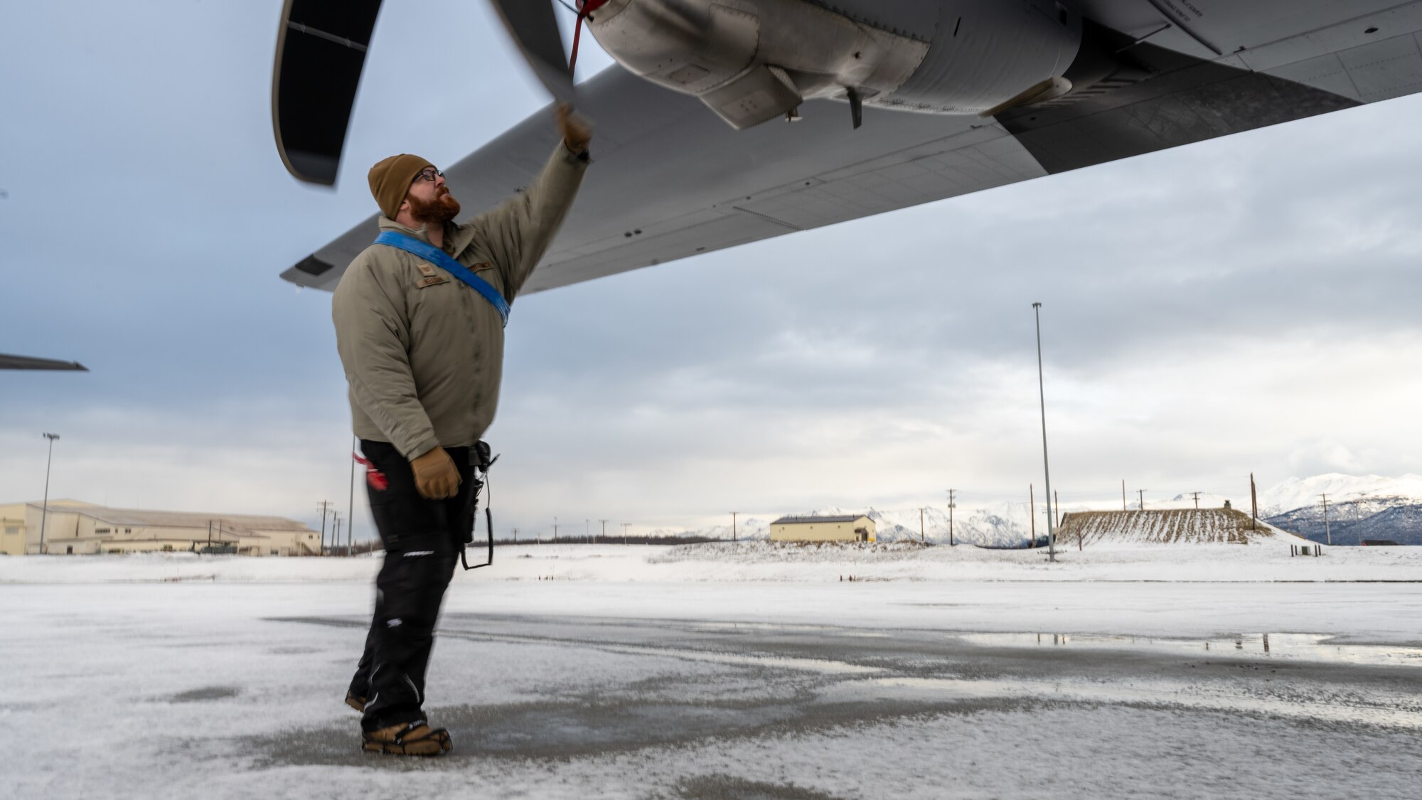 U.S. Air Force Tech. Sgt. Tyler Nelson, 317th Aircraft Maintenance Squadron flying crew chief and Lethal Expeditionary Airman Development course graduate, checks a C-130J Super Hercules propeller during Joint Pacific Multinational Readiness Center exercise 25-02 at Joint Base Elmendorf-Richardson, Alaska, Jan. 22, 2025. Nelson taught proper winter safety considerations for propeller rotation to members of his 18-Airmen team, ensuring his team could proactively handle the extreme cold weather conditions. (U.S. Air Force photo by Airman 1st Class Jade M. Caldwell)