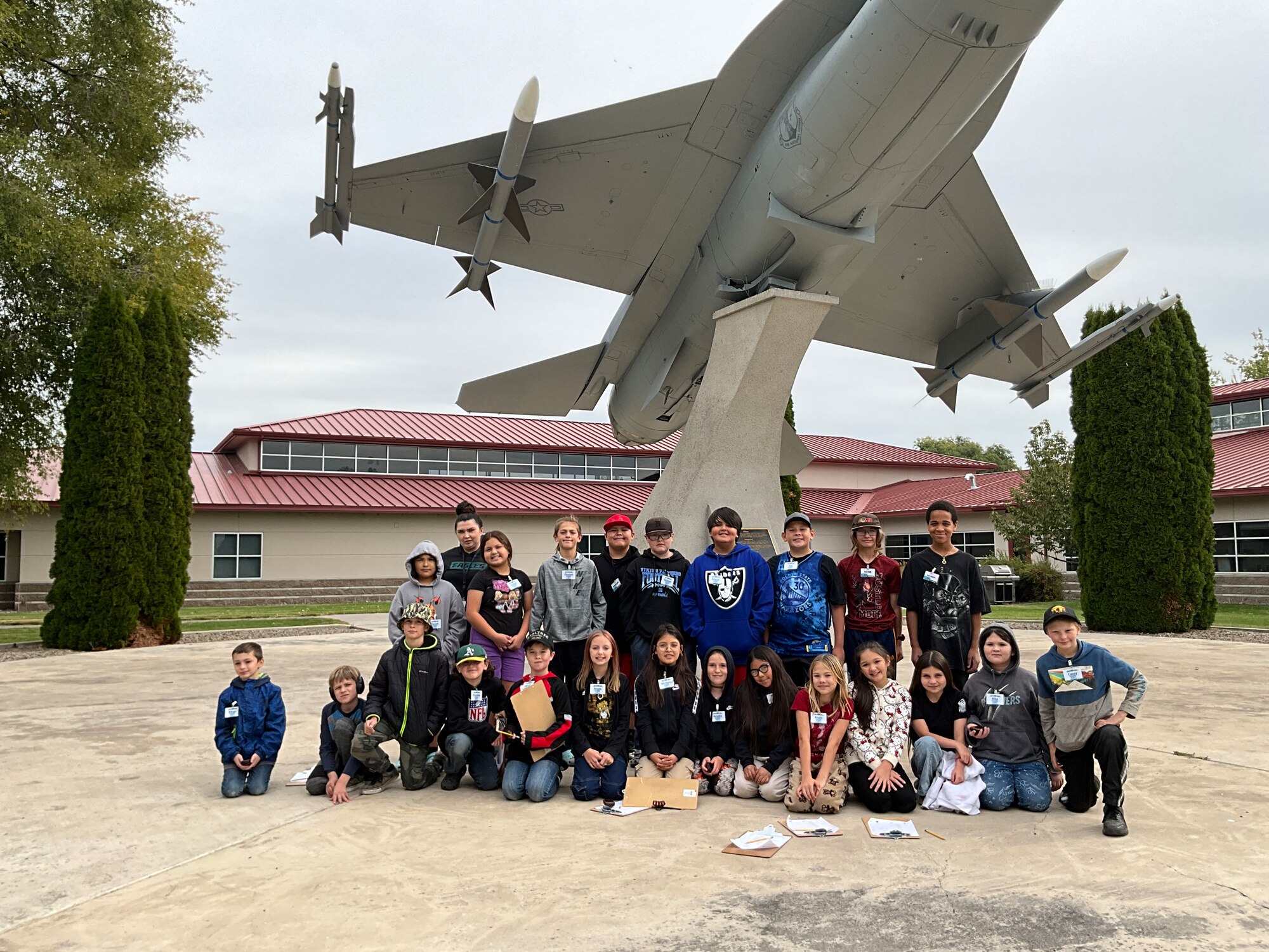 Students stand in front of a jet