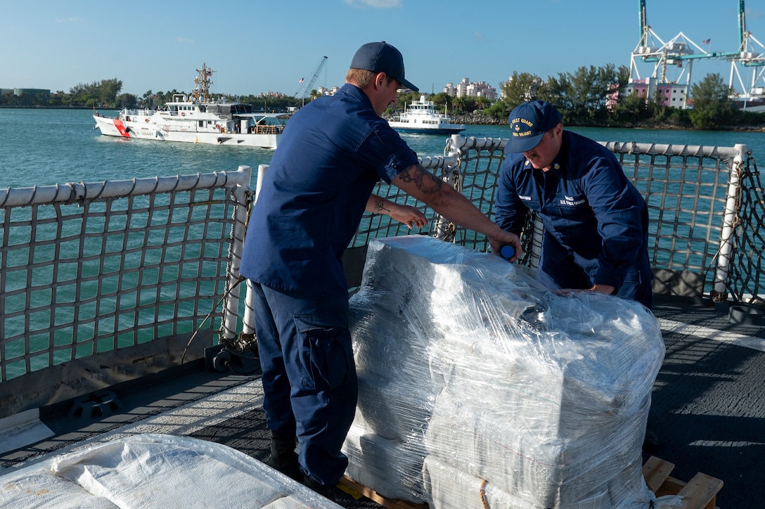 Crew members from USCGC Valiant (WMEC 621) using plastic wrap to bind interdicted narcotics at Base Miami Beach, Florida, Mar. 6, 2025. The Valiant's crew secured the illegal drugs after six interdictions in the international waters of the Caribbean. (U.S. Coast Guard photo by Petty Officer 3rd Class Nicholas Strasburg)