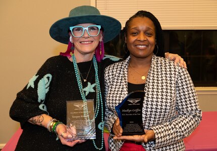 women hold trophies