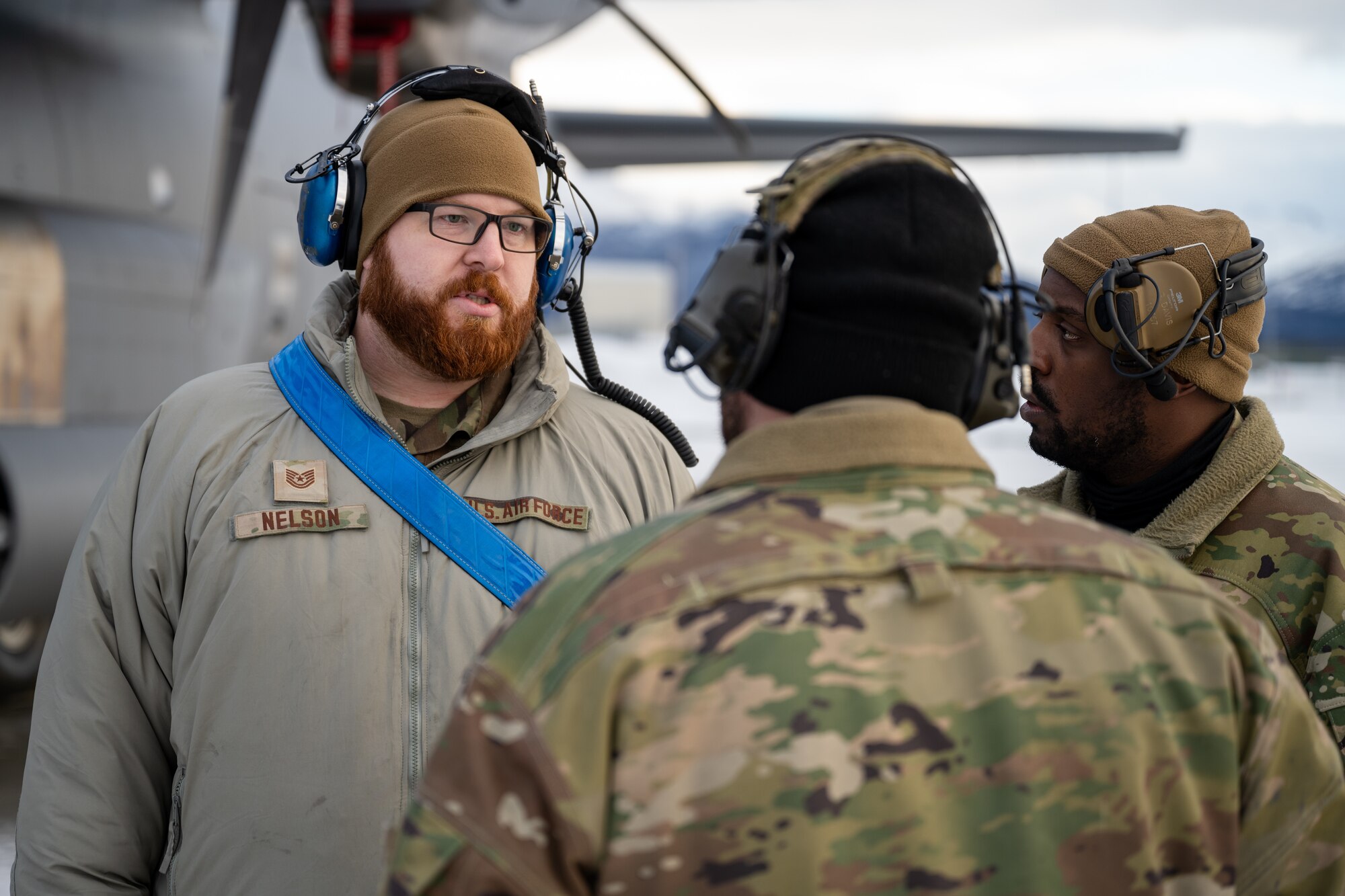U.S. Air Force Tech. Sgt. Tyler Nelson, 317th Aircraft Maintenance Squadron flying crew chief and Lethal Expeditionary Airman Development course graduate, discusses aircraft status with 317th AMXS Airmen during Joint Pacific Multinational Readiness Center exercise 25-02 at Joint Base Elmendorf-Richardson, Alaska, Jan. 22, 2025. The 18-Airmen team supported over 100 other Air Force maintainers across multiple wings and allowed the 40th AS to strengthen joint Arctic capabilities by delivering fully mission-capable aircraft during JPMRC 25-02. (U.S. Air Force photo by Airman 1st Class Jade M. Caldwell)