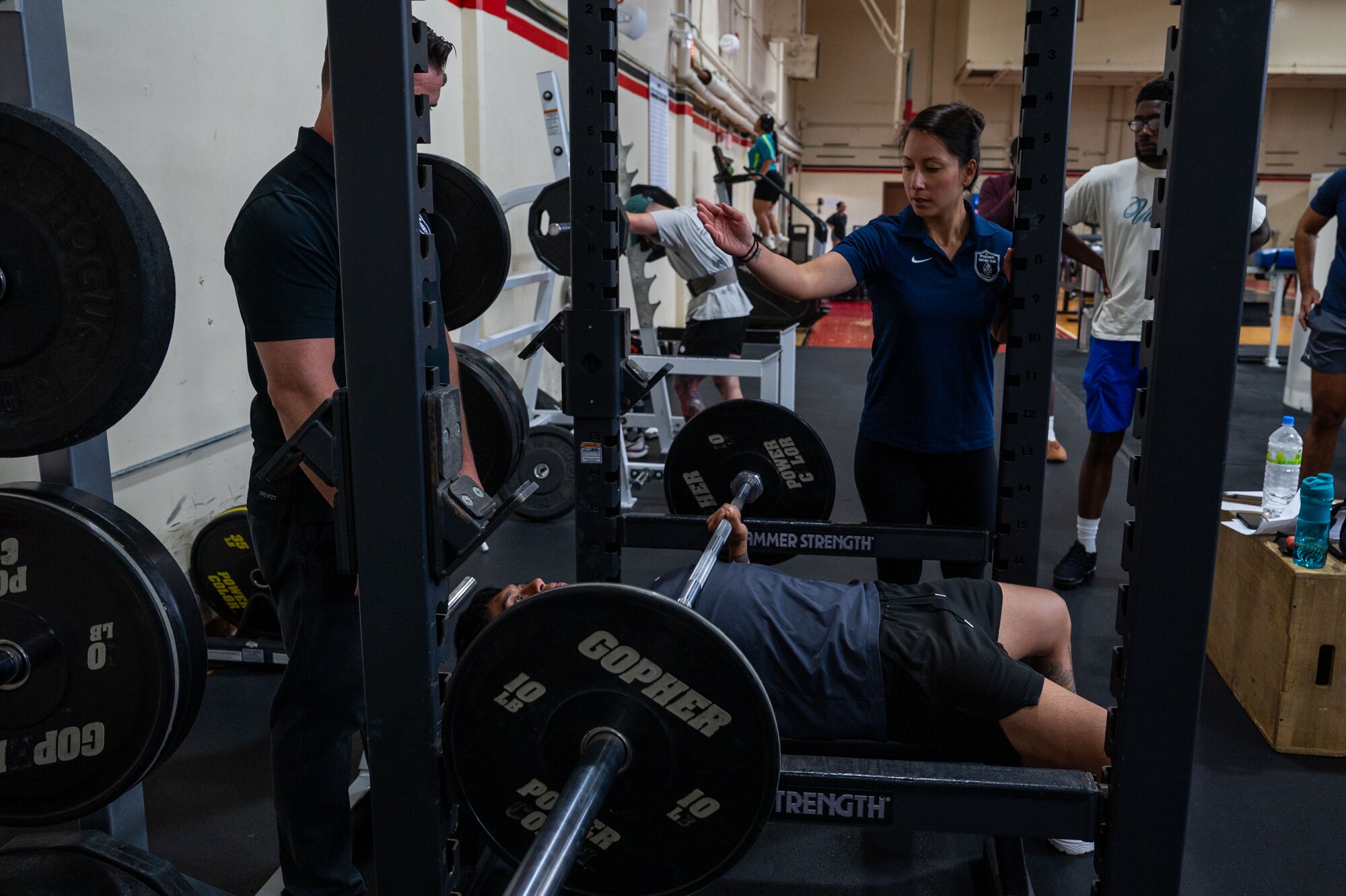 Jasmin Wenzel, 36th Wing Operation Support Team strength and conditioning specialist, instructs members from the 36th Security Forces Squadron on how to teach others how to bench press at Andersen Air Force Base, Guam, Feb. 26, 2025. The SFS members will use their new knowledge to help bolster unit physical training sessions. (U.S. Air Force photo by Senior Airman Audree Campbell)