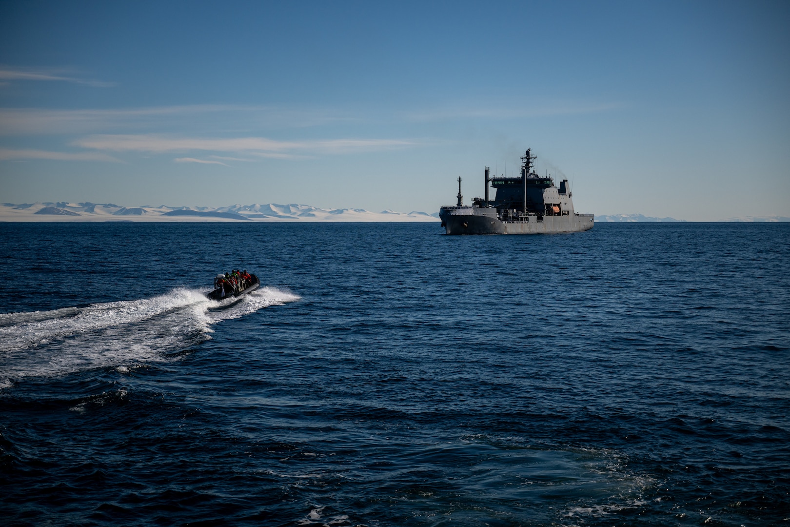 Crewmembers from U.S. Coast Guard Cutter Polar Star (WAGB 10) transit McMurdo Sound on a small boat from the New Zealand Defense Force vessel HMNZS Aotearoa for a crew exchange in McMurdo Sound during Operation Deep Freeze, Feb. 7, 2025. Operation Deep Freeze works closely with other Antarctic programs to include those of New Zealand, Australia and Italy, as well as their respective defense forces. (U.S. Coast Guard photo by Petty Officer 2nd Class Briana Carter)