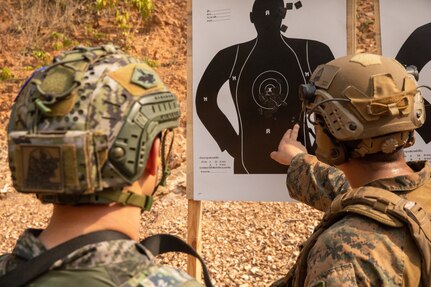U.S. Marine Corps Cpl. Mario Salas, right, a light armored reconnaissance Marine with 1st Light Armored Reconnaissance Battalion, 1st Marine Division, checks shots from a Republic of Korea Marine Corps service member during a live-fire short bay range at Thai Reconnaissance Battalion, Sattahip, Thailand, Feb. 28, 2025.