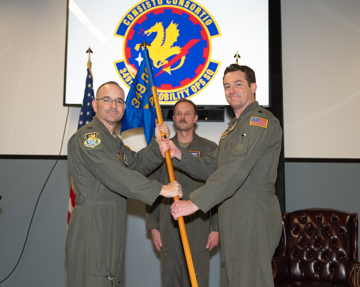 Col Romeo and Lt Col Jones hold guidon during ceremony.