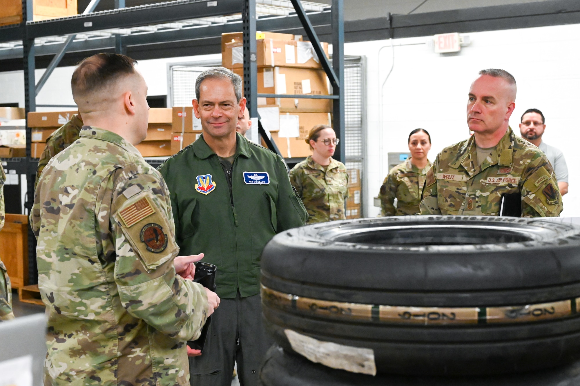 Group of Airman receive a brief at a warehouse.