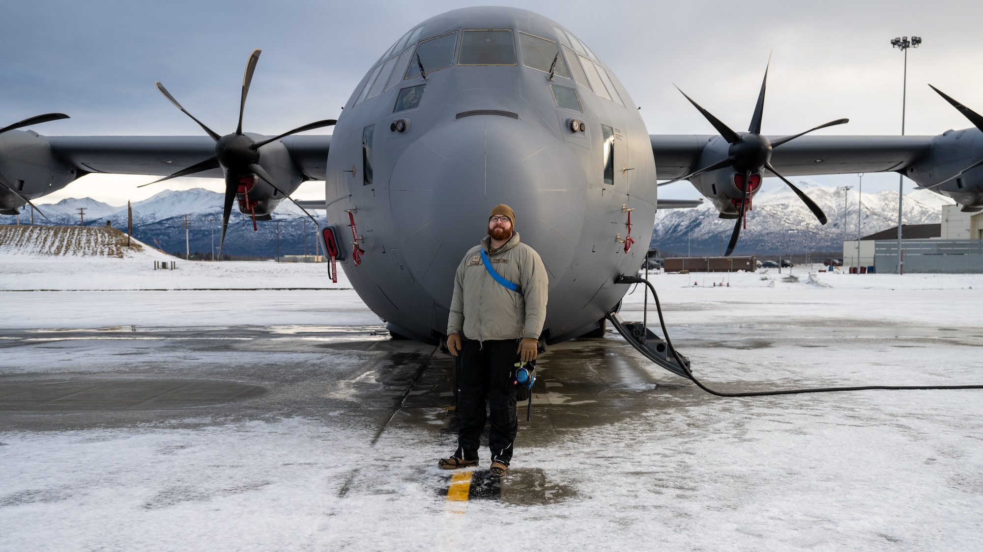 U.S. Air Force Tech. Sgt. Tyler Nelson, 317th Aircraft Maintenance Squadron flying crew chief and Lethal Expeditionary Airman Development course graduate, stands in front of a C-130J Super Hercules during Joint Pacific Multinational Readiness Center exercise 25-02 at Joint Base Elmendorf-Richardson, Alaska, Jan. 22, 2025. JPMRC 25-02 tested what Nelson learned from the LEAD program to succeed in operationally limited environments and allowed him to lead and train a maintenance team in extreme cold weather conditions. (U.S. Air Force photo by Airman 1st Class Jade M. Caldwell)