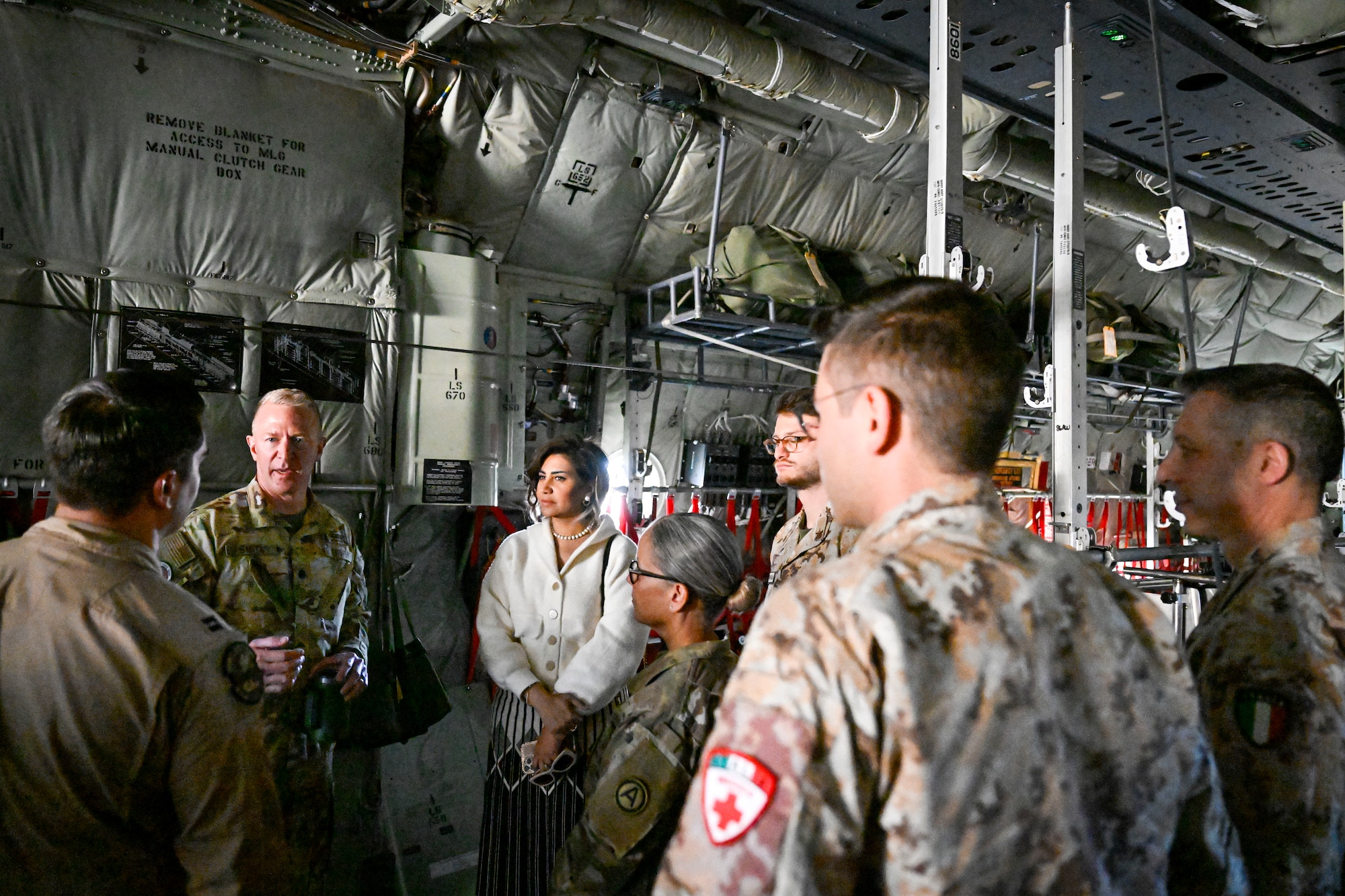 People in uniform conversate inside an aircraft.