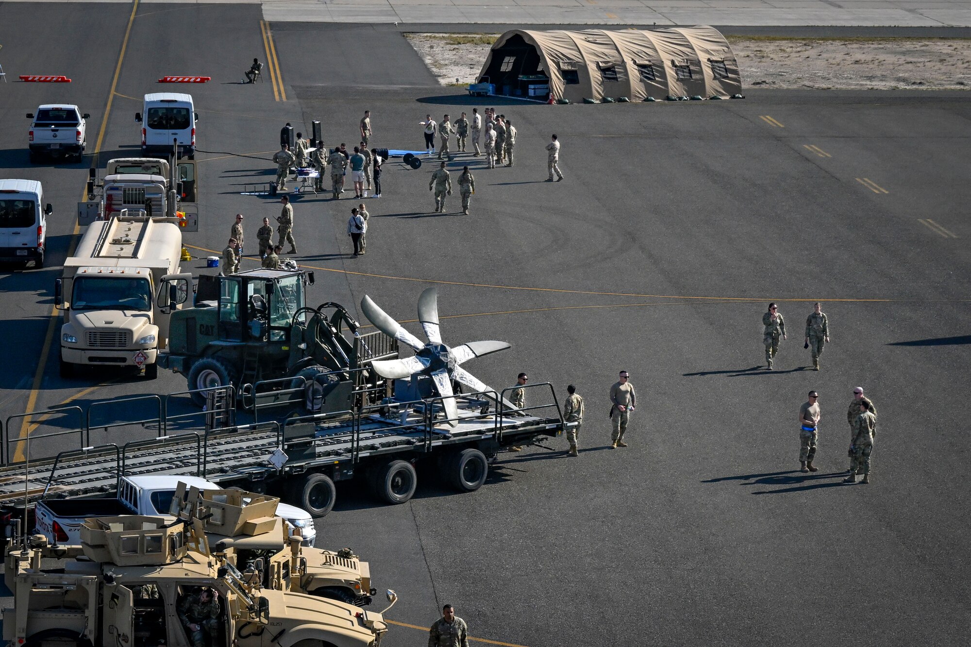 People walk around next to static vehicle displays.
