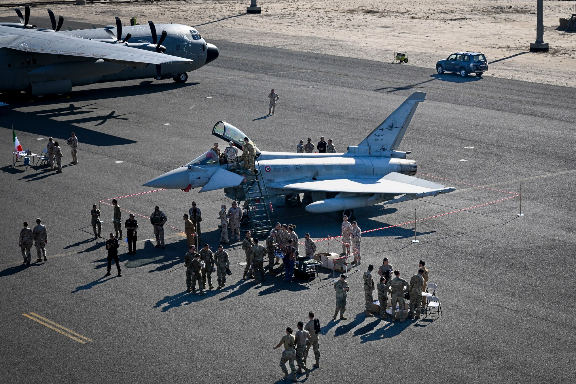 People in uniform surround a fighter jet.