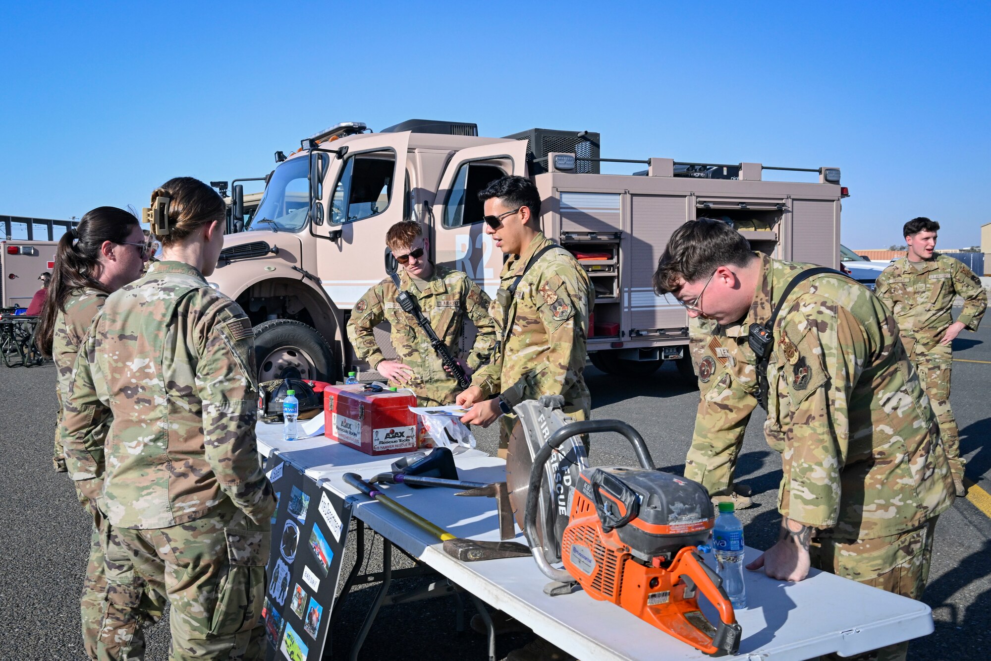 People in uniform talk at a table.