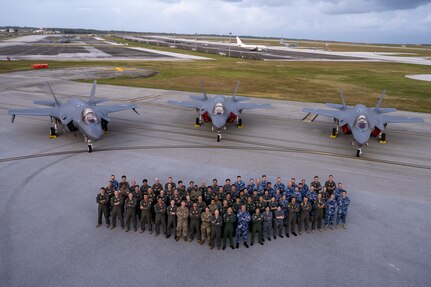 Allies from the United States, Japan and Australia come together on the flightline in front of three F-35A Lightning IIs to celebrate the end of exercise Cope North 2025 at Andersen Air Force Base, Guam, Feb. 21, 2025.