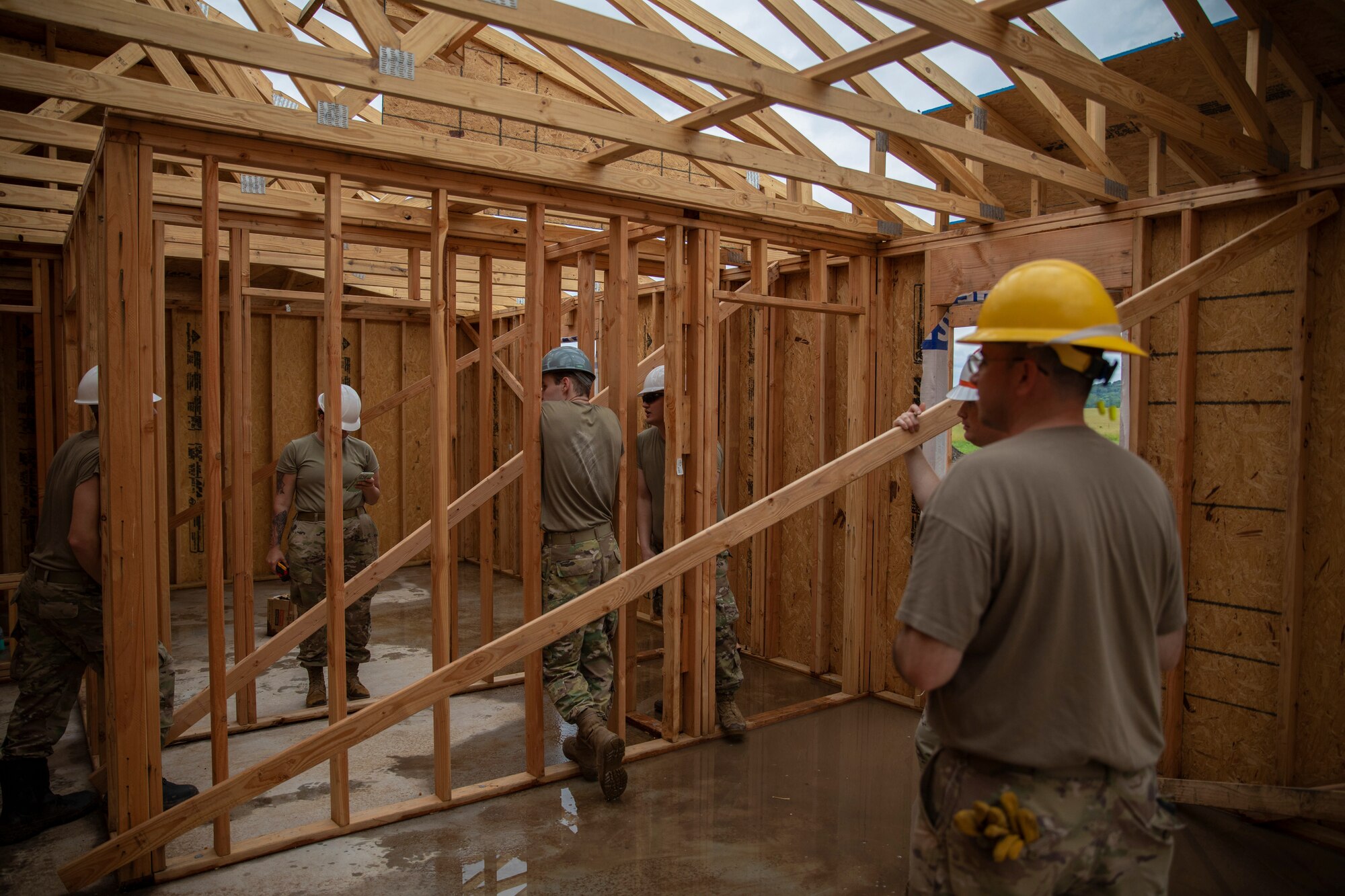 A group of National Guard Airmen plan and block the electrical components for one of seven houses being built at the Innovative Readiness Training construction site in Tahlequah, Oklahoma, June 6, 2022.