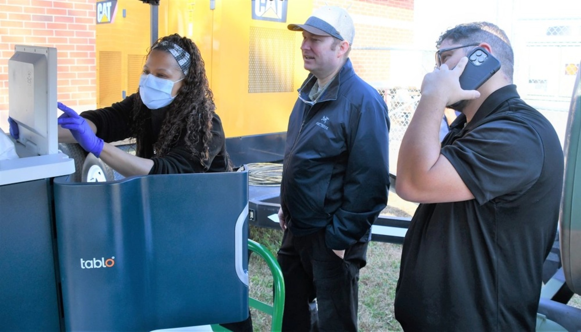 Tiffany Wise (L) and Dr. David De Blasio, Medical Director for the Medical Service Line at Womack (C) monitor a machine while testing if dialysis can be successful in an austere environment.